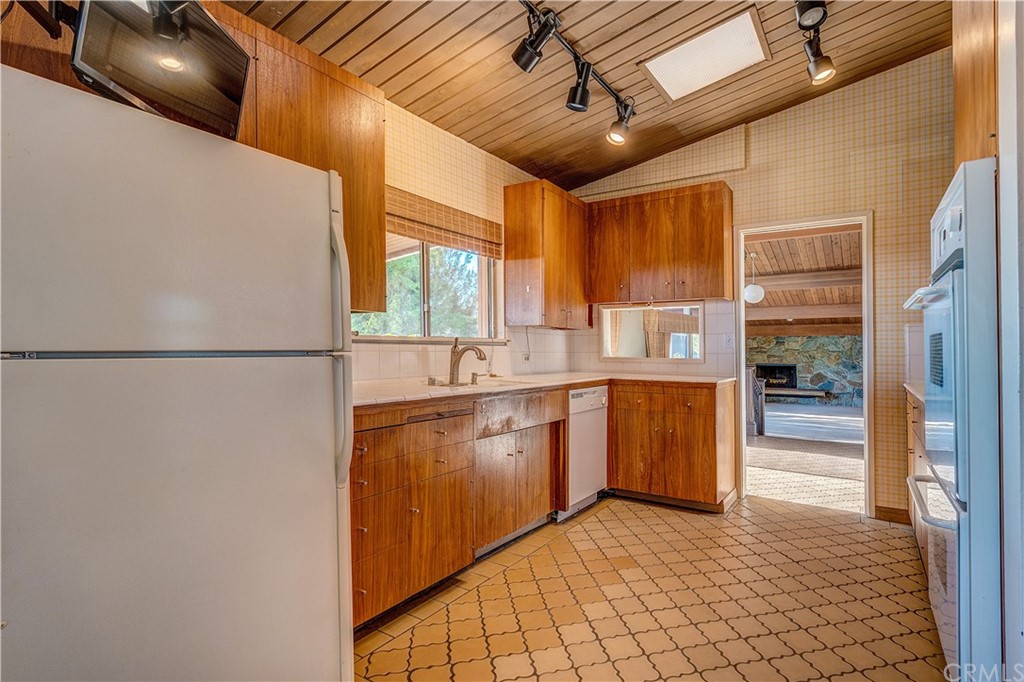 7214 Canyon Drive Whittier, CA 90602 - Photo 8 of 40 a kitchen with stainless steel appliances granite countertop a refrigerator a sink and white cabinets