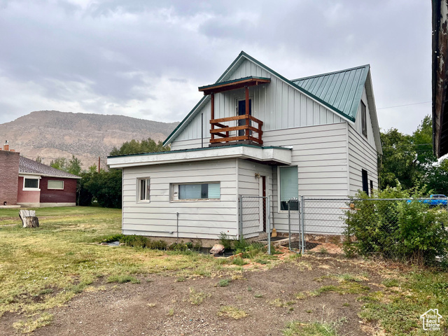 350 West Main Street Emery, UT 84522 - Photo 17 of 28 Rear view of property featuring board and batten siding, a metal roof, and a mountain view