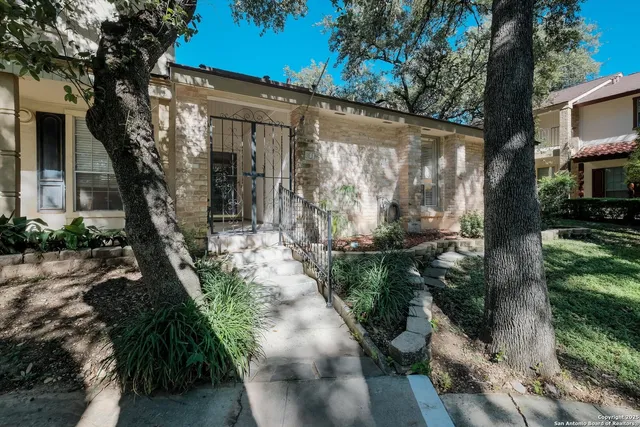 a front view of a house with a yard and potted plants