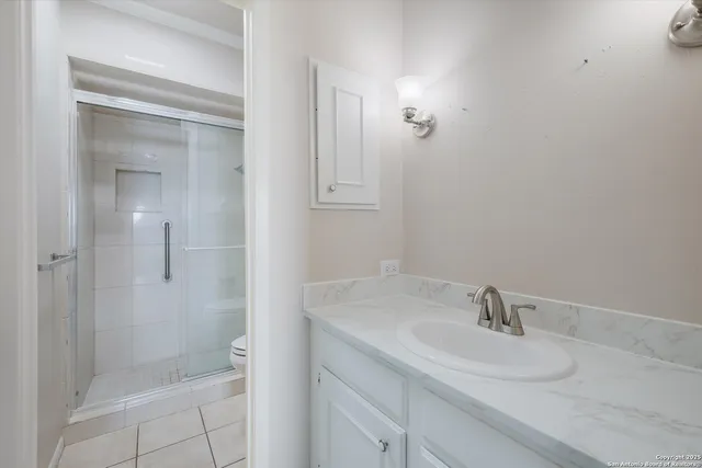 a bathroom with a sink shower and a mirror