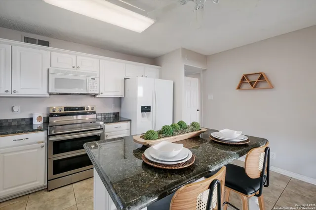 a kitchen with stainless steel appliances granite countertop a stove a sink and a refrigerator