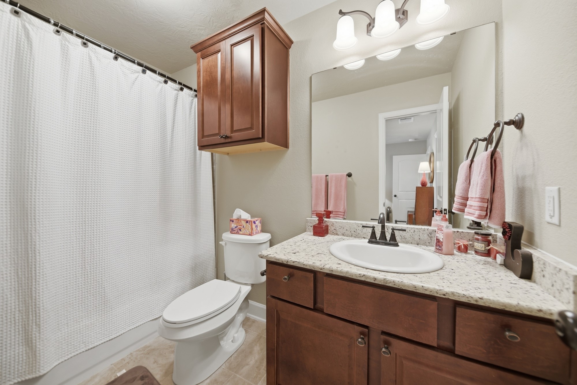 2205 Ralston Creek Court Brenham, TX 77833 - Photo 30 of 37 a bathroom with a granite countertop sink toilet and mirror