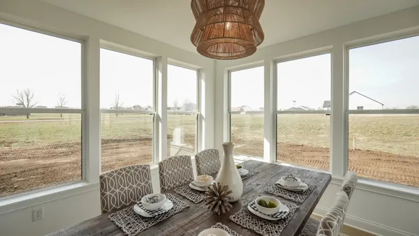a living room with furniture and floor to ceiling windows