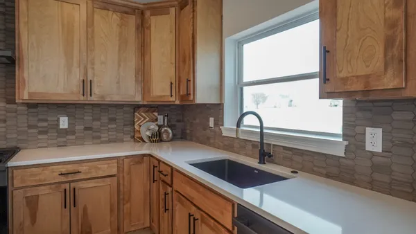 a kitchen with stainless steel appliances granite countertop a sink a window and cabinets