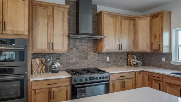 a kitchen with stainless steel appliances a stove a sink and cabinets