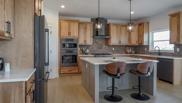 a kitchen with kitchen island a counter space a sink appliances and cabinets