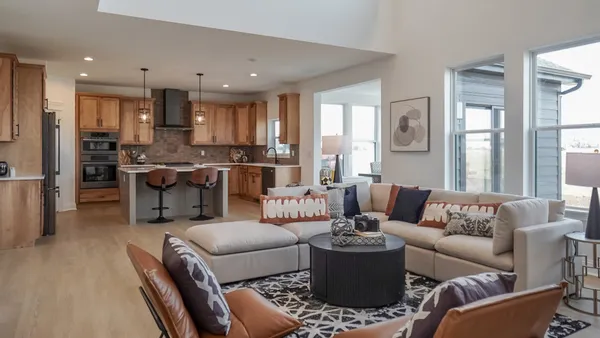 a living room with furniture kitchen view and a large window