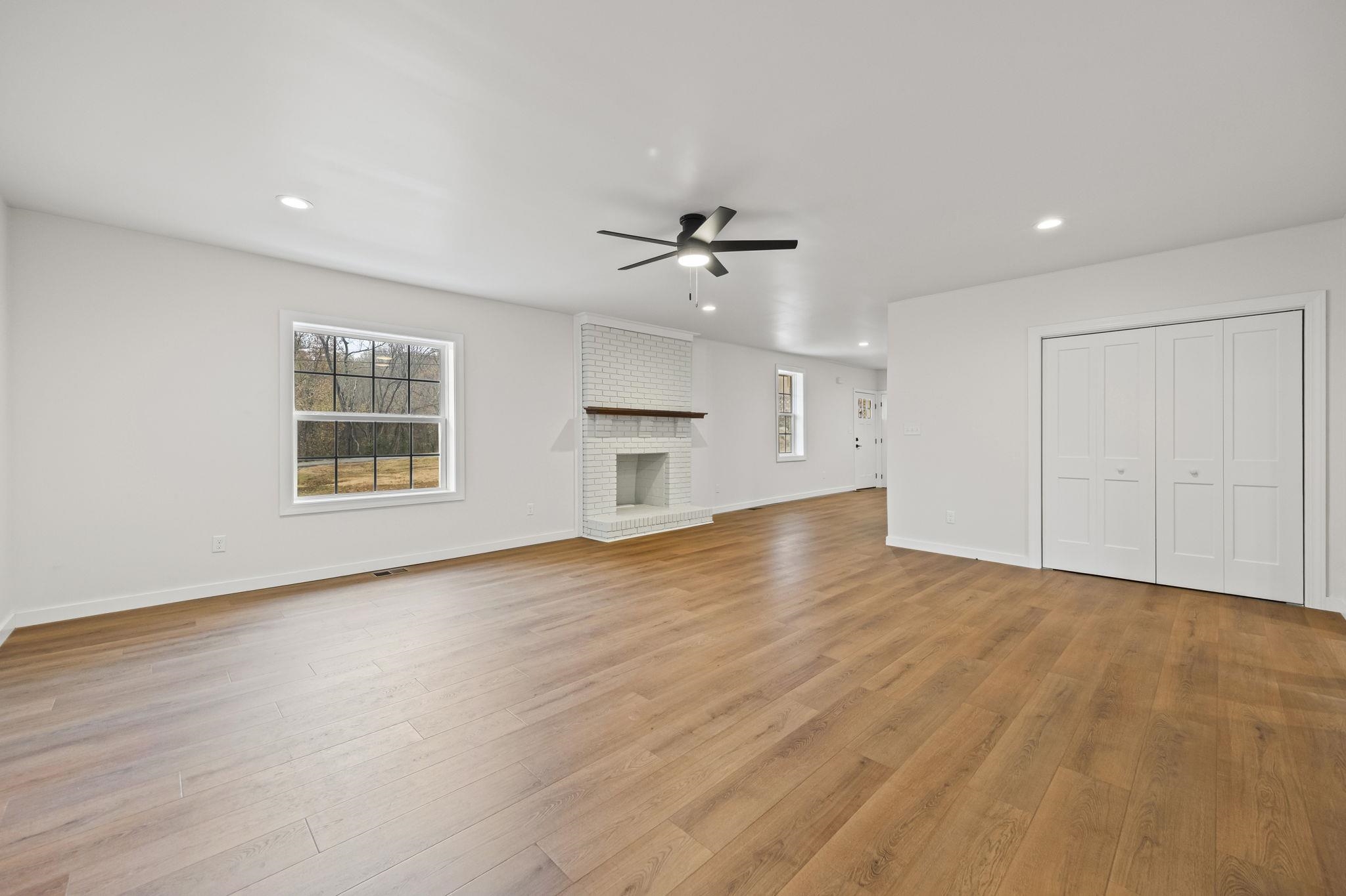 835 Curve Woodville Road Gates, TN 38037 - Photo 4 of 30 Unfurnished living room with recessed lighting, light wood-type flooring, a brick fireplace, and ceiling fan