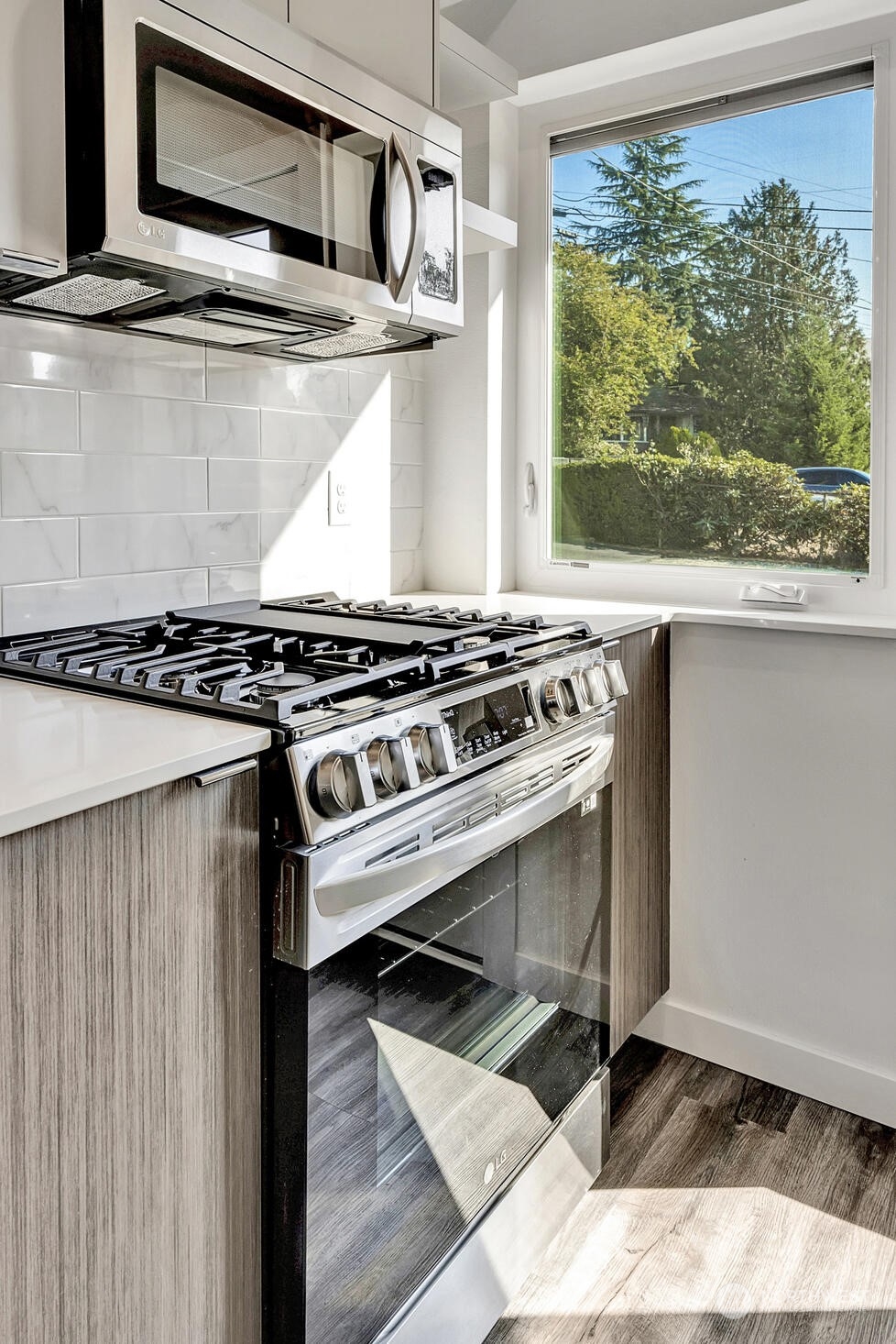 10170 Holman Road Northwest, Unit E Seattle, WA 98133 - Photo 3 of 12 a stove top oven sitting inside of a kitchen