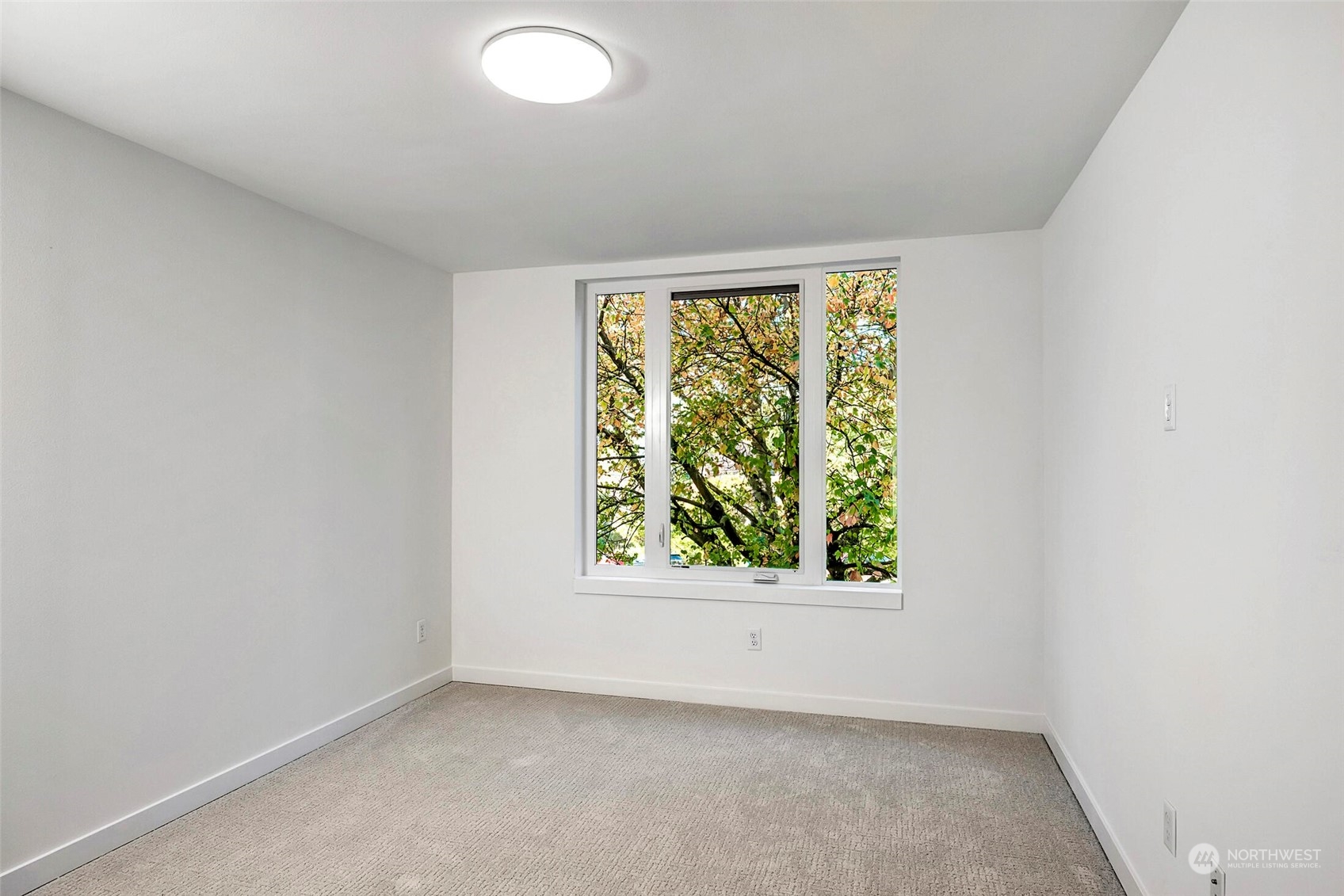 10170 Holman Road Northwest, Unit E Seattle, WA 98133 - Photo 7 of 12 an empty room with windows