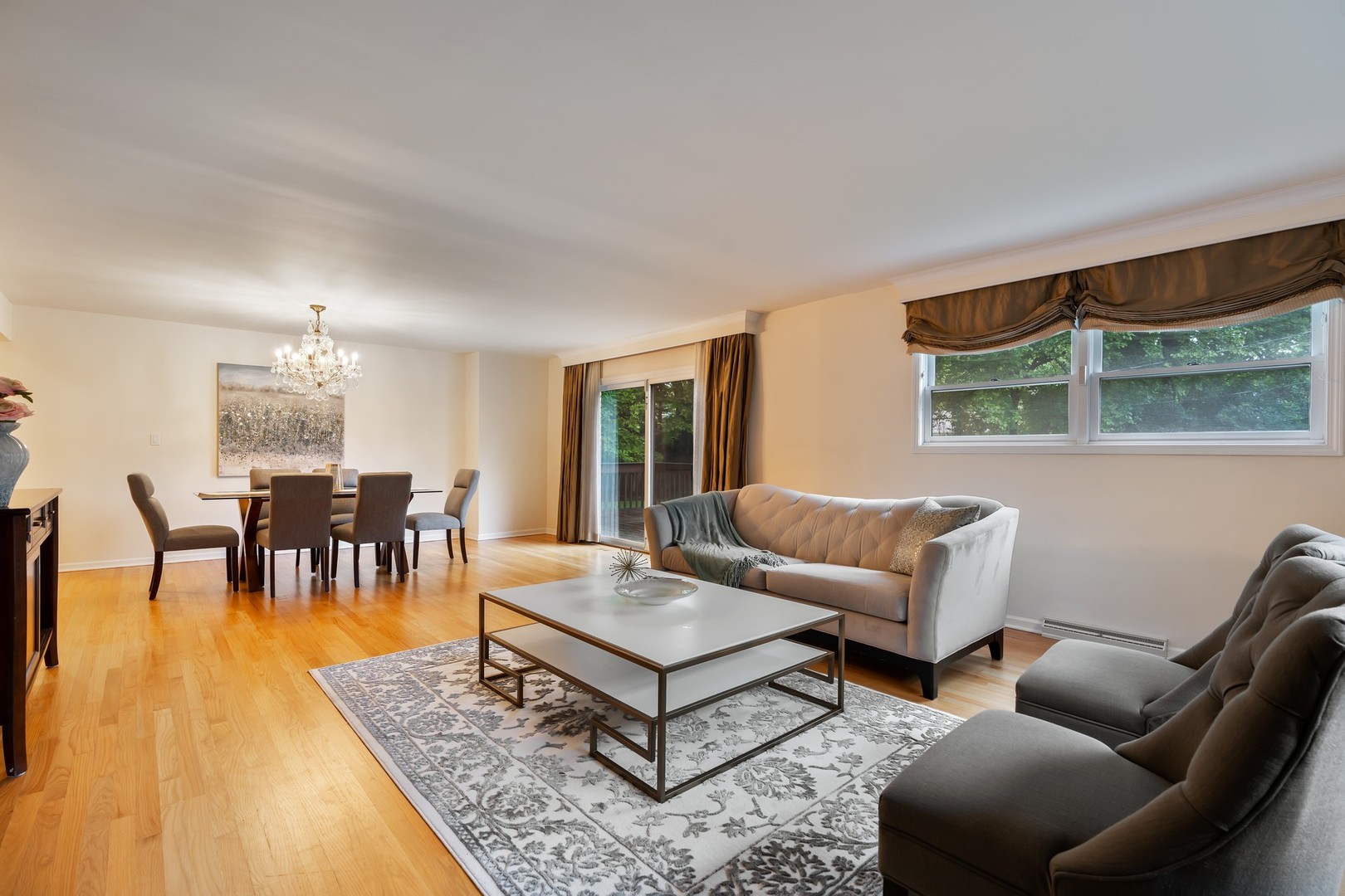 336 Beverly Drive Wilmette, IL 60091 - Photo 5 of 34 a living room with furniture and a dining table with garden view