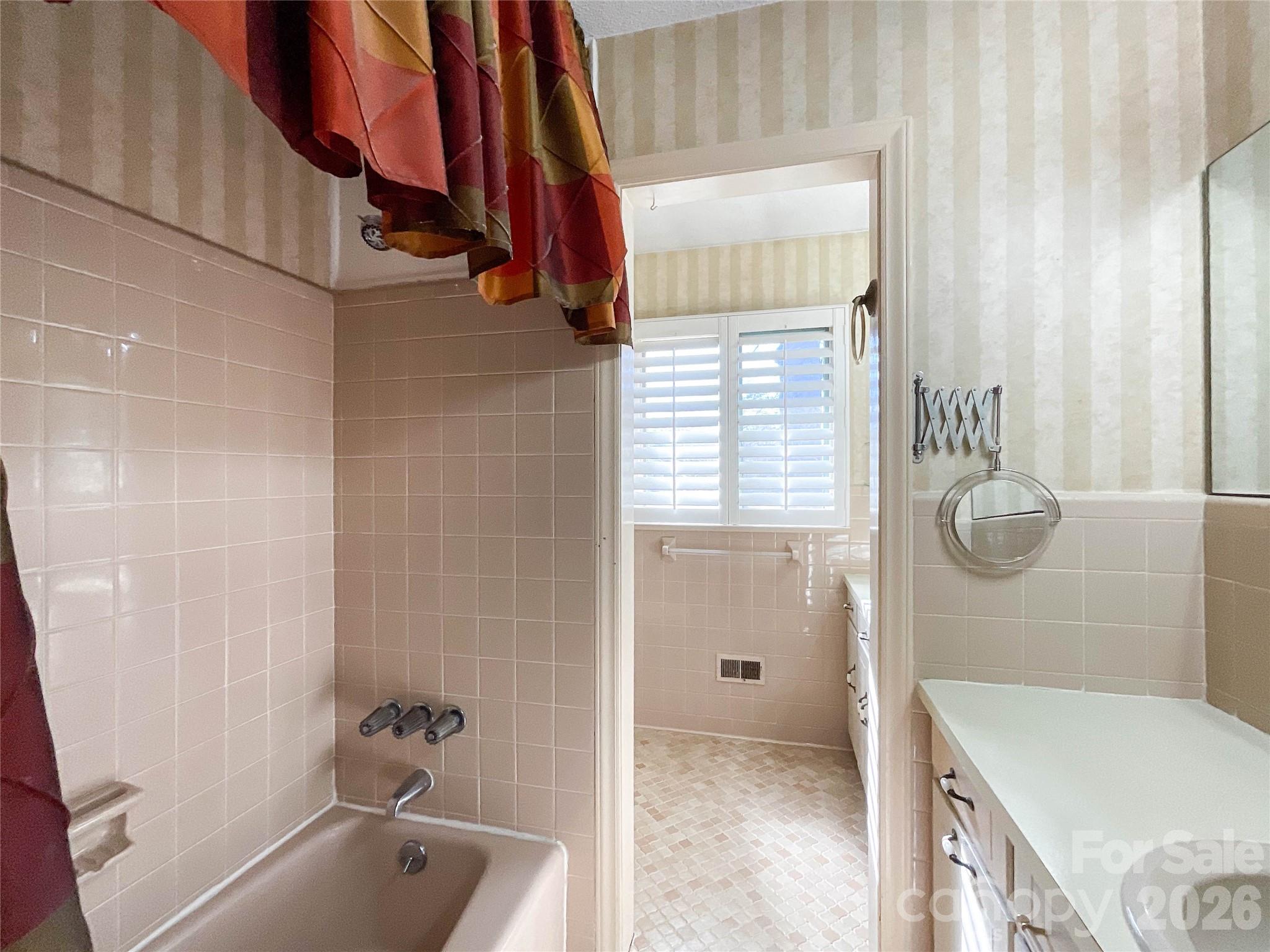 13909 Idlewild Road Matthews, NC 28105 - Photo 27 of 48 a bathroom with a tub a sink and a shower curtain