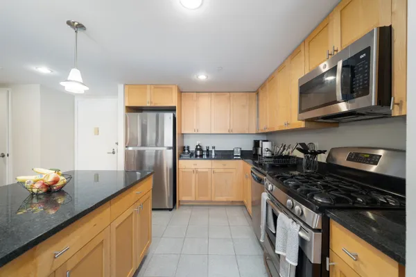 a kitchen with stainless steel appliances granite countertop a stove a sink and a microwave