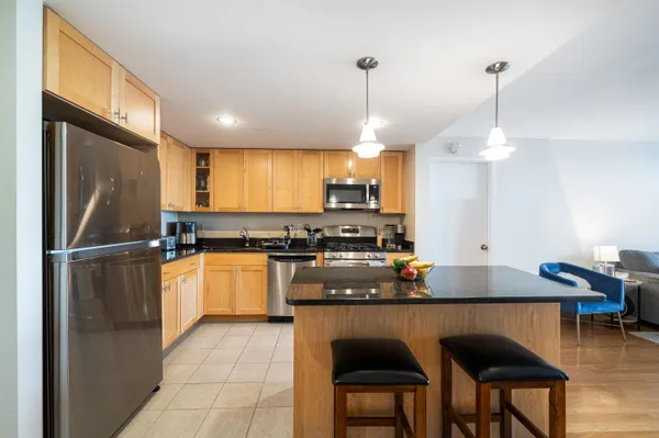 a kitchen with kitchen island a counter space a sink appliances and cabinets