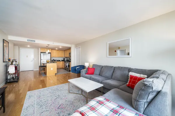 a living room with furniture and view of kitchen