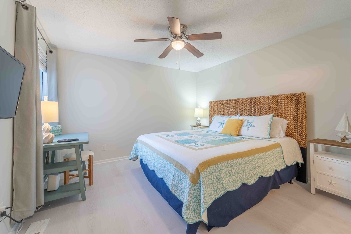 2562 Forest Ridge Drive, Unit P2 Fernandina Beach, FL 32034 - Photo 15 of 23 a bedroom with a bed and a chandelier
