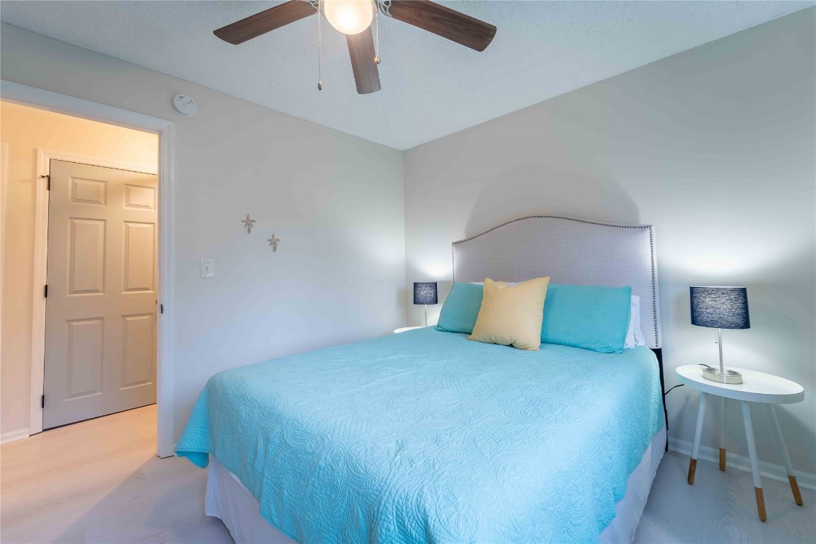 2562 Forest Ridge Drive, Unit P2 Fernandina Beach, FL 32034 - Photo 20 of 23 a large bed sitting in a bedroom next to a window and a chandelier