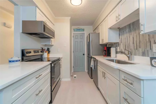 a kitchen with stainless steel appliances a sink dishwasher stove and refrigerator