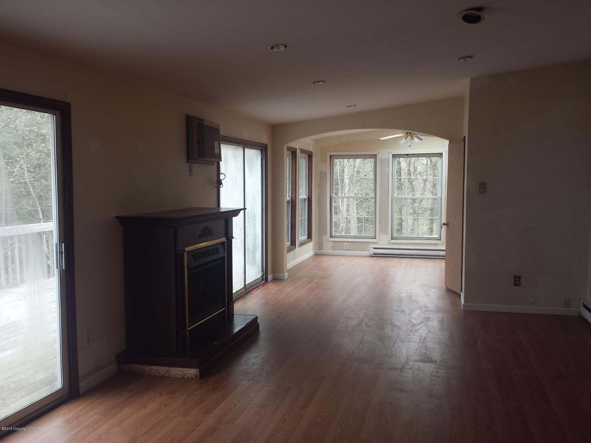 5766 Decker Road Bushkill, PA 18324 - Photo 6 of 13 an empty room with wooden floor and windows
