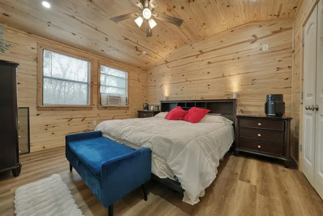 a bed sitting in a spacious bedroom next to a larger window