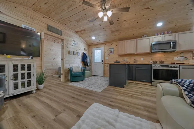 a kitchen with kitchen island granite countertop a sink cabinets and stainless steel appliances