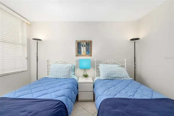 a bedroom with two beds and painting on the wall