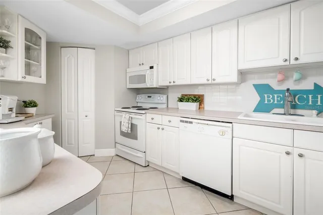 a kitchen with white cabinets and white appliances