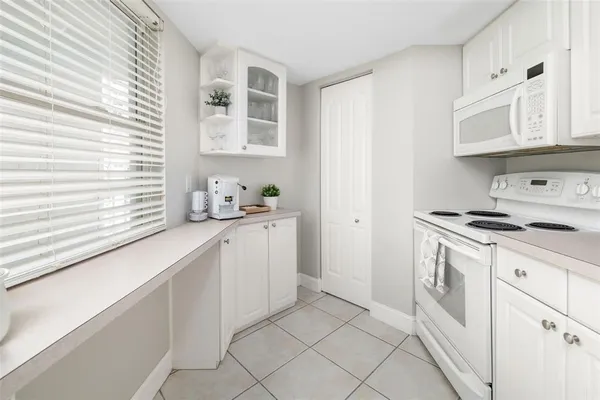 a kitchen with white cabinets and white appliances