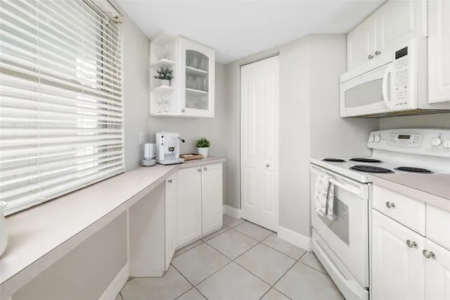 a kitchen with white cabinets and white appliances
