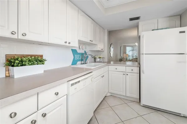 a kitchen with white cabinets and white appliances
