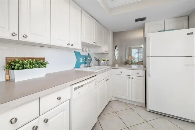 a kitchen with white cabinets and white appliances