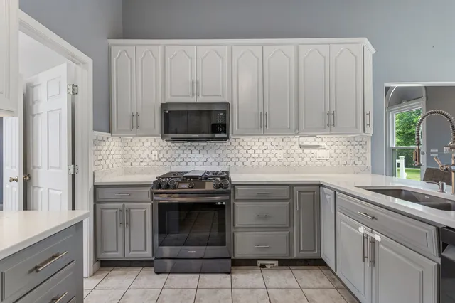 a kitchen with stainless steel appliances granite countertop a stove a microwave and cabinets