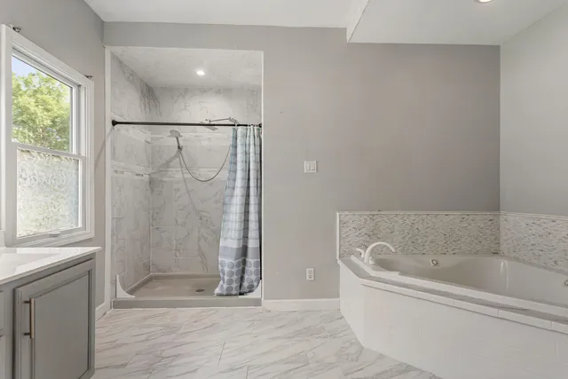a bathroom with a bathtub and shower