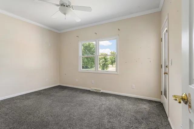 an empty room with a window and a fan