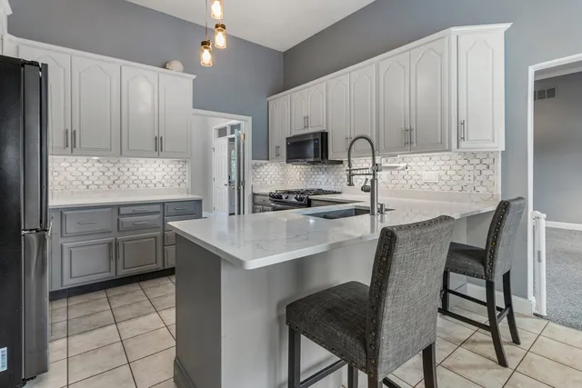 a kitchen with stainless steel appliances a table chairs and a refrigerator