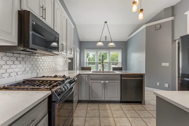 a kitchen with stainless steel appliances sinks a stove and a refrigerator