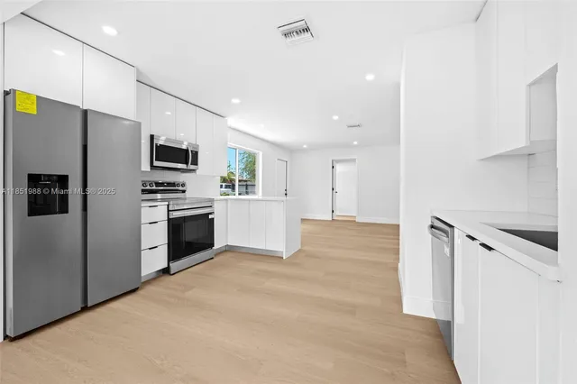 a kitchen with a refrigerator a stove top oven a sink and dishwasher