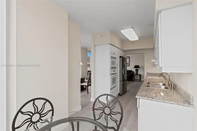 a kitchen with granite countertop a sink stainless steel appliances refrigerator and cabinets