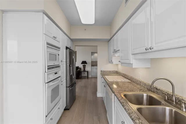 a kitchen with a sink a counter top space stainless steel appliances and a window