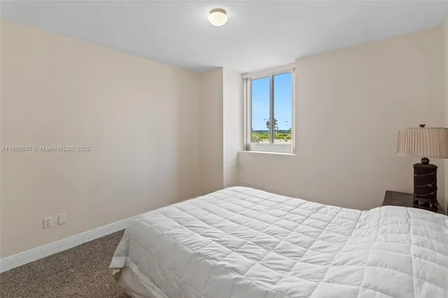 a bedroom with a bed and a flat tv screen on a dresser