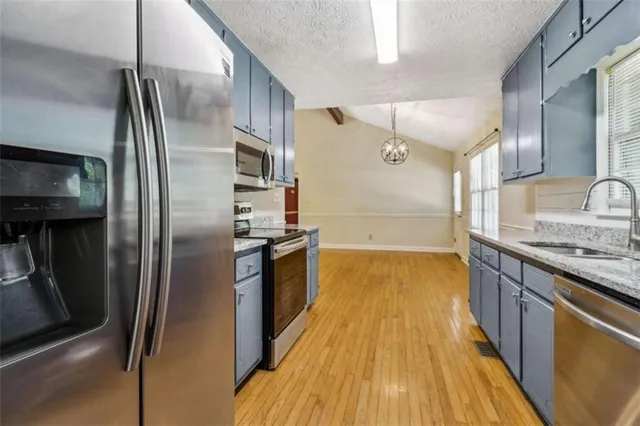 a kitchen with granite countertop a sink and stainless steel appliances