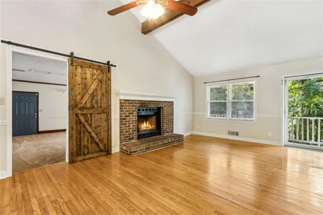 a view of empty room with wooden floor and fireplace