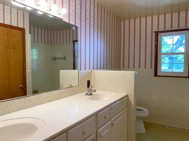 a bathroom with a sink a toilet and shower curtain