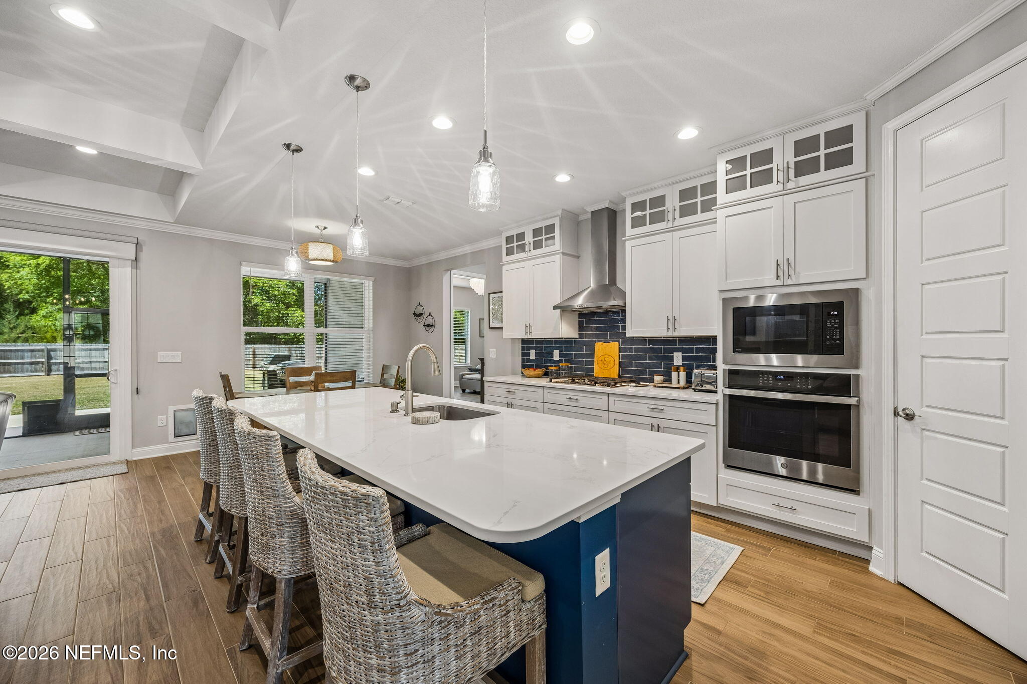 85949 Miner Pines Yulee, FL 32097 - Photo 8 of 55 a kitchen with stainless steel appliances a stove a refrigerator a sink and white cabinets with wooden floor