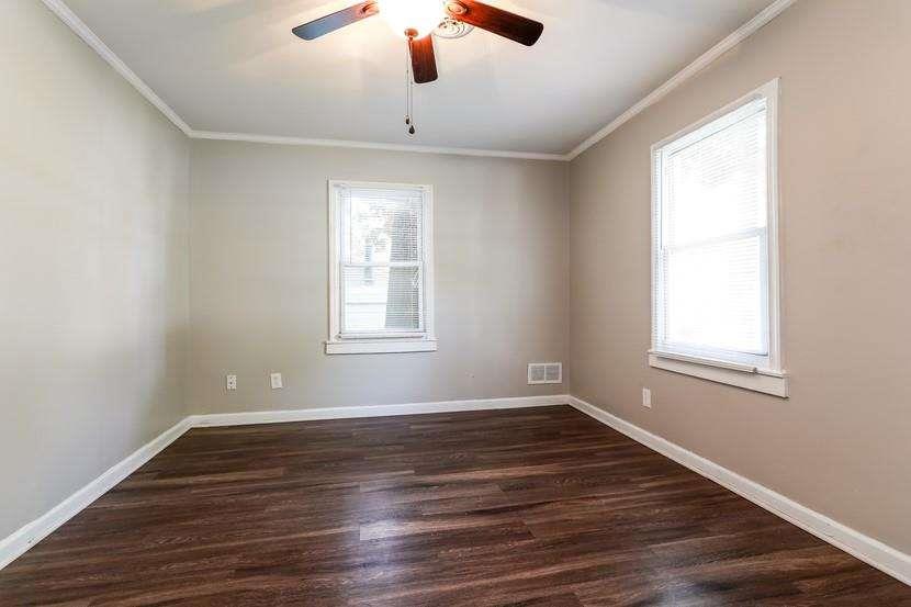 3993 Forrest Court Chamblee, GA 30341 - Photo 4 of 14 an empty room with wooden floor chandelier fan and windows