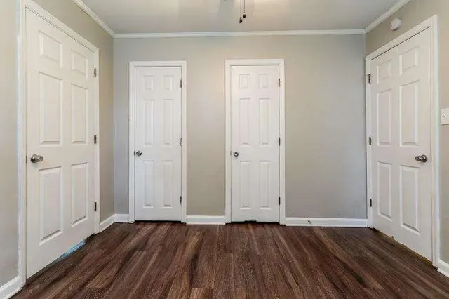 an empty room with wooden floor and closet area