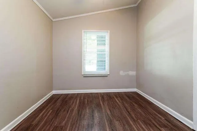 a view of a room with wooden floor and window