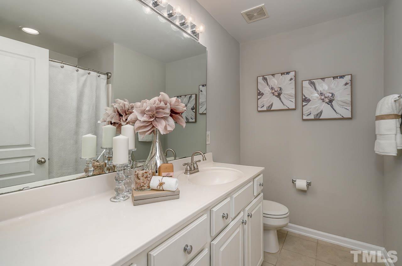 6022 Viking Drive Raleigh, NC 27612 - Photo 9 of 11 a bathroom with a sink a mirror and a toilet