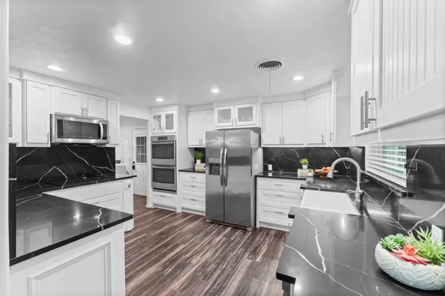 a kitchen with stainless steel appliances granite countertop a sink refrigerator and microwave