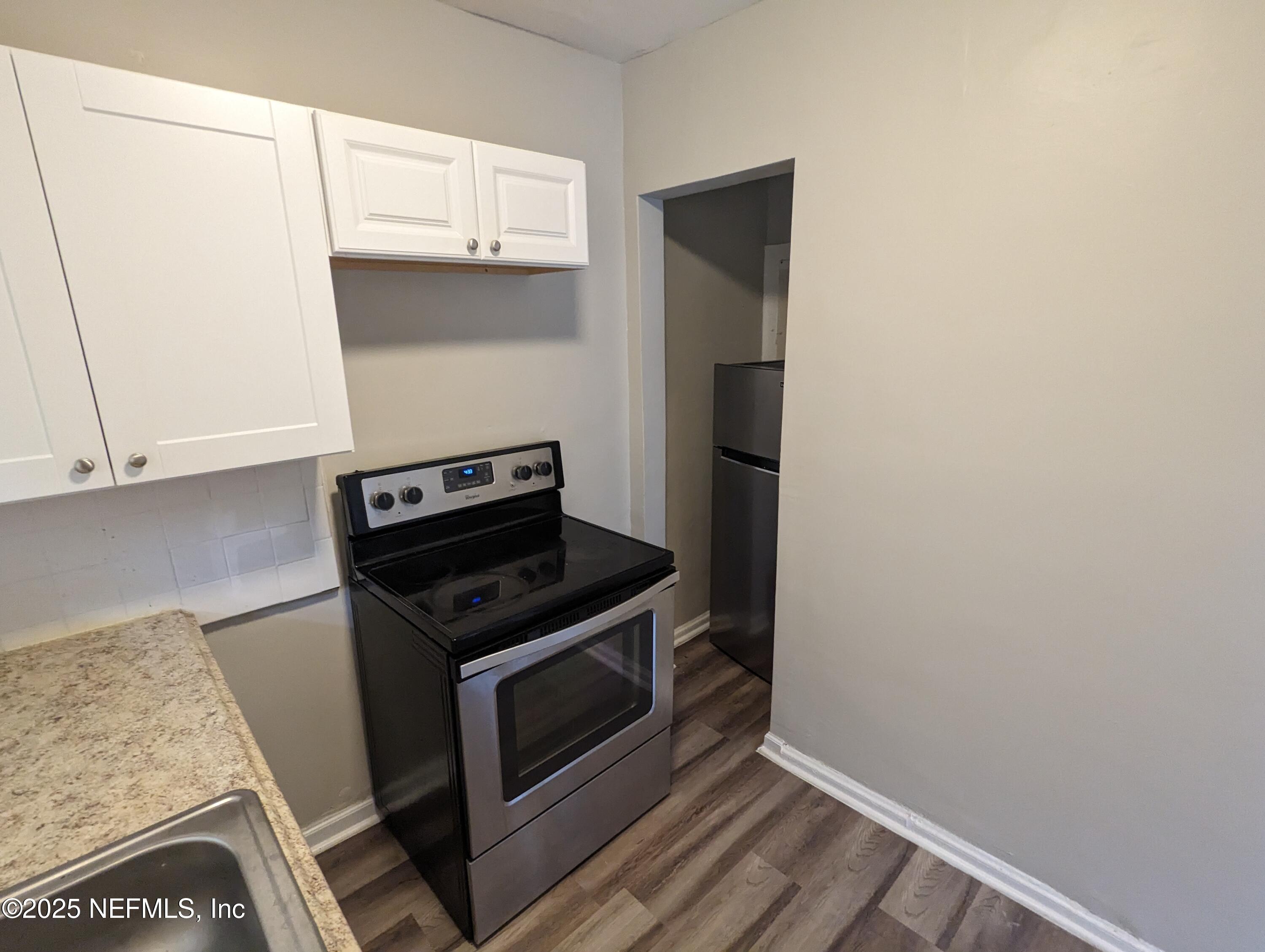 1204 Cherry Street Jacksonville, FL 32205 - Photo 25 of 32 a kitchen with granite countertop white cabinets and stainless steel appliances